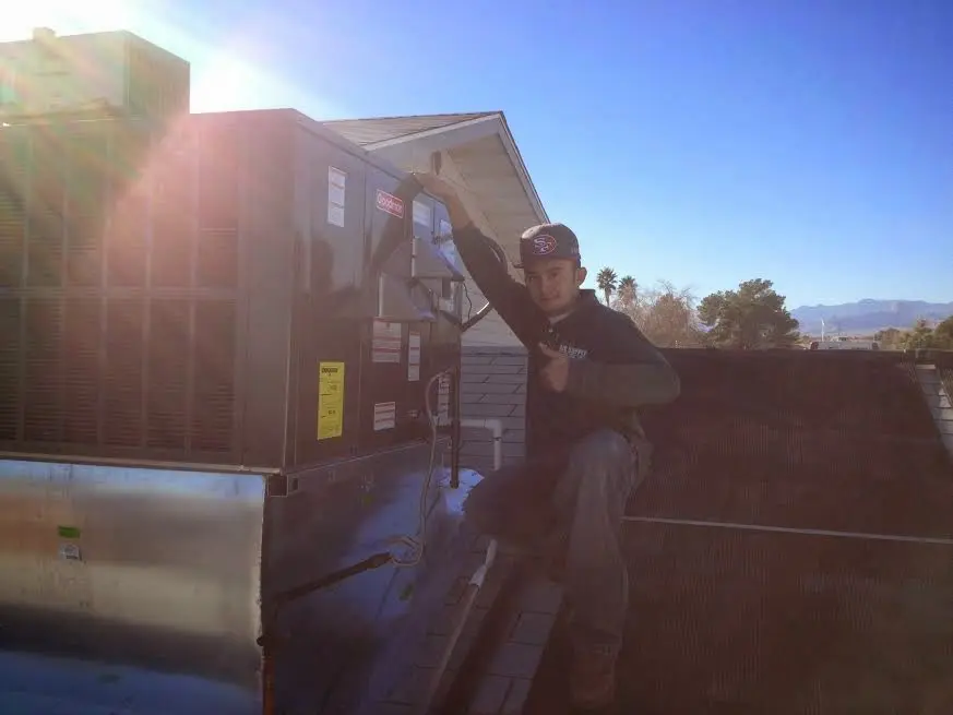 HVAC technician performing AC Tune-Up on a rooftop unit in Bessemer